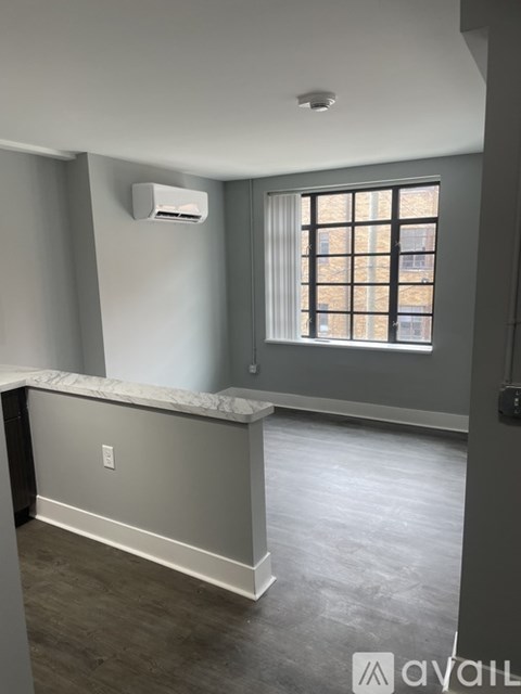A room with a window and a wall-mounted air conditioner unit.