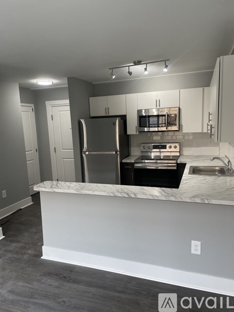 A kitchen with a marble countertop and stainless steel appliances.