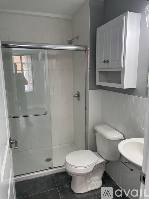 A white toilet sits in a bathroom next to a walk-in shower.
