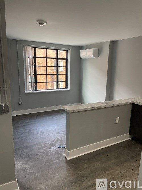 A room with a window and a wall-mounted air conditioner unit.