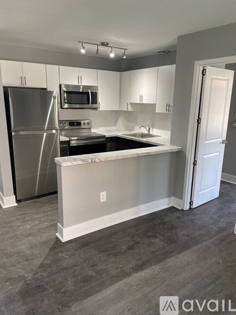 A kitchen with a white island and stainless steel appliances.