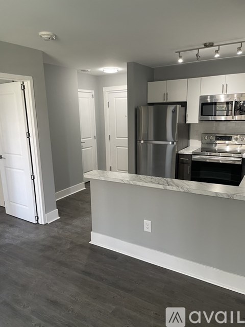 A kitchen with a refrigerator, microwave, and oven.