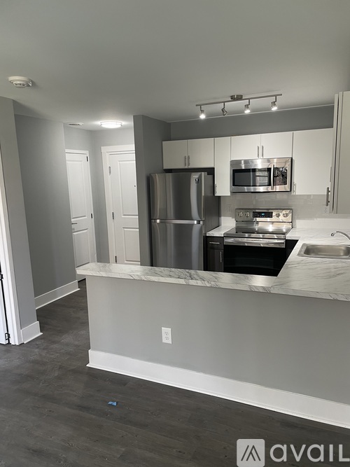 A kitchen with a refrigerator, microwave, and oven.