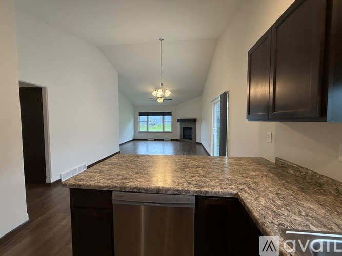 A kitchen with white cabinets and a marble countertop.