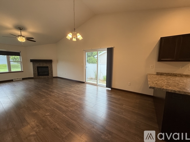 A spacious room with wood flooring and a ceiling fan.