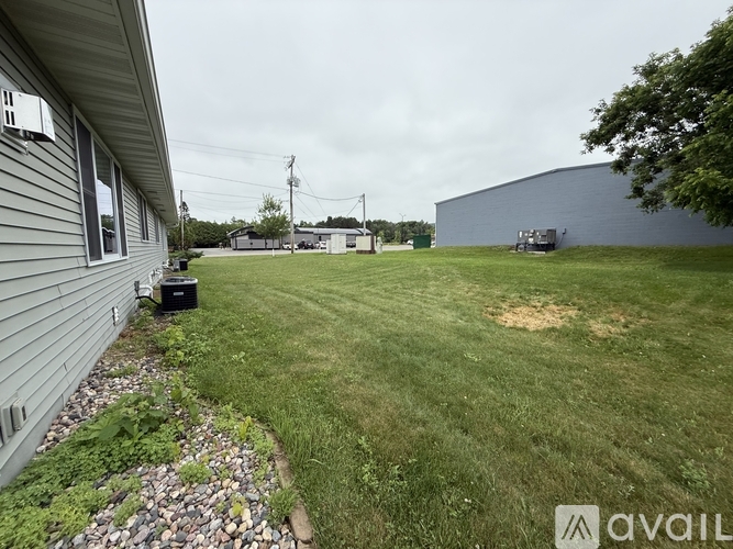 A backyard with a grassy area, a building, and a utility vehicle.