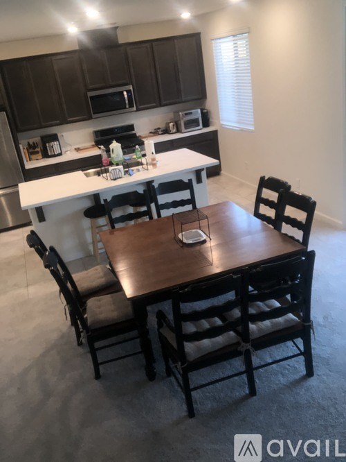 A kitchen with a table and chairs in the foreground.