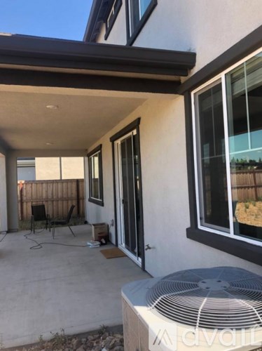 A patio with a fan and a chair.