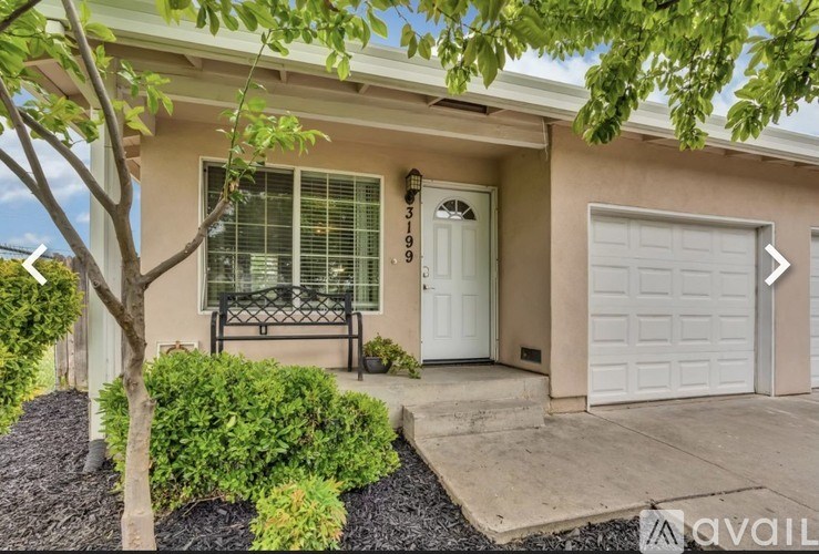 A house with a white garage door and a black gate.