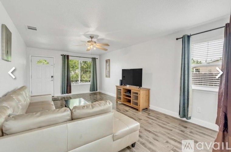 A living room with a beige couch and a flat screen TV.