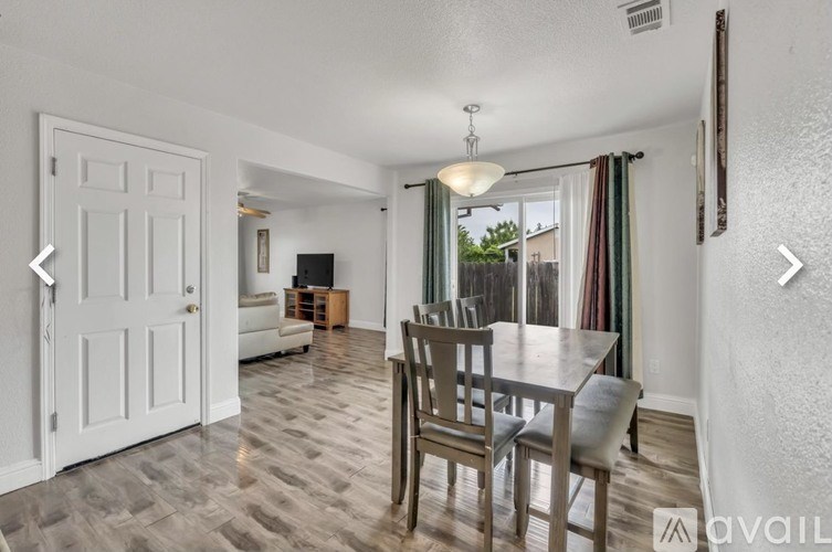 A dining room with a table and chairs.