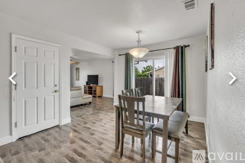 A dining room with a table and chairs.