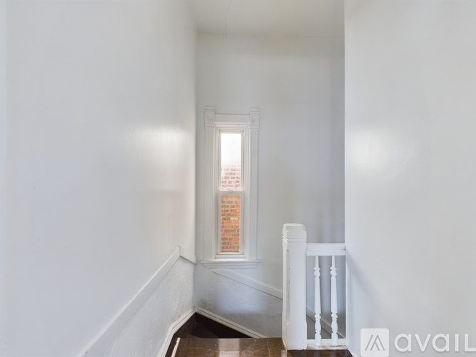 A white room with a window and a white railing.