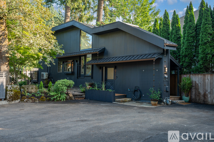 A modern house with a grey exterior surrounded by trees.