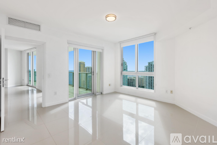 A spacious, empty room with a view of the cityscape outside the windows.