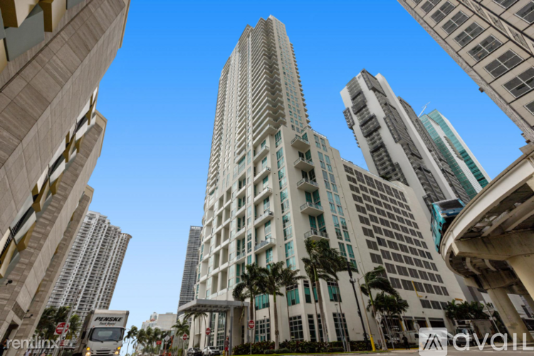 A tall building with many windows stands in front of other buildings.