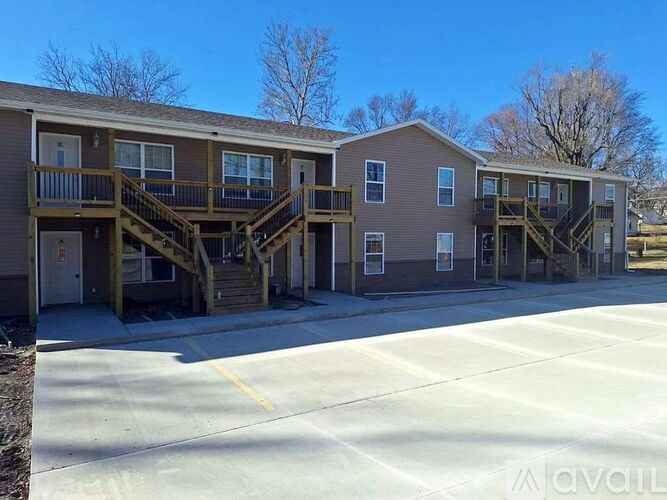 Apartment complex with a parking lot in front.