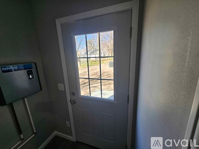 A white door with a glass window is open.