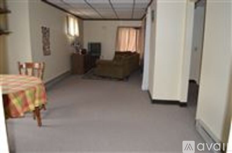 A living room with a couch, chair, and television.