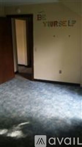 A room with a wall that says "Be yourself" on it.