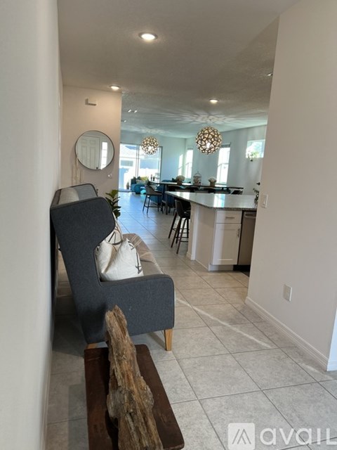 A living room with a grey chair and a wooden table.