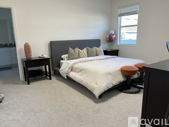 A bedroom with a bed, nightstand, and chair.