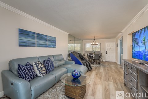 A living room with a grey couch and a glass coffee table.