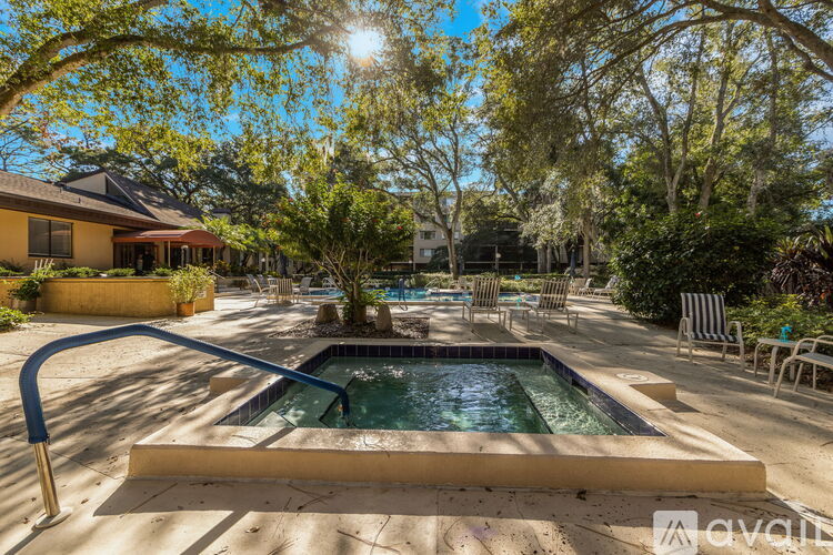 A sunny backyard with a pool and patio furniture.