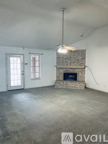 A room with a fireplace and a ceiling fan.