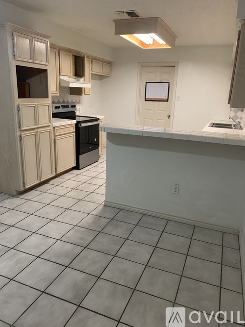 A kitchen with white cabinets and a black stove top oven.