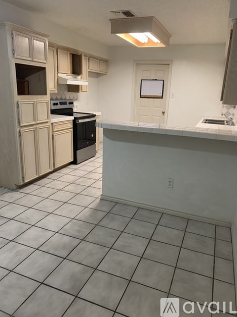 A kitchen with white cabinets and a black stove top oven.