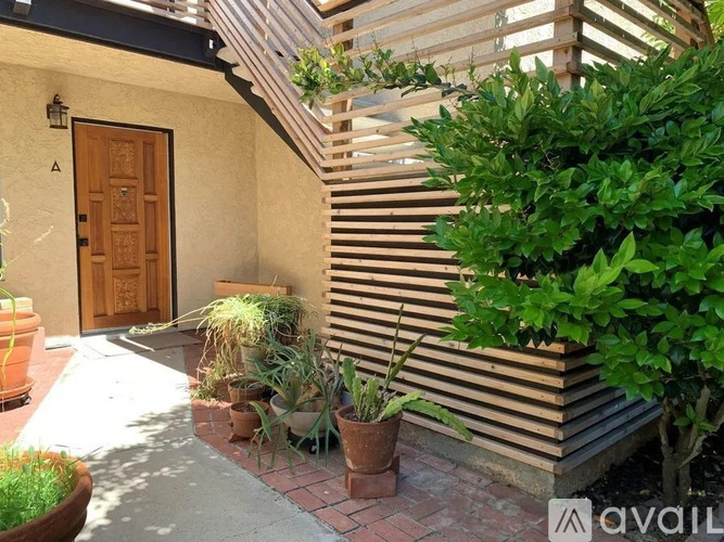 A house with a brown door and a small garden in front.