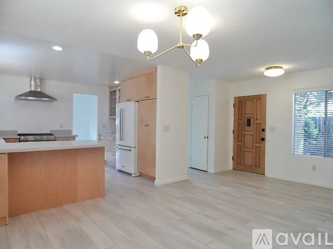 A kitchen with a refrigerator, stove, and a countertop.