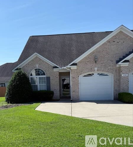 A house with a garage and a driveway in front.