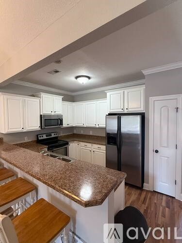 A kitchen with granite countertops and white cabinets.