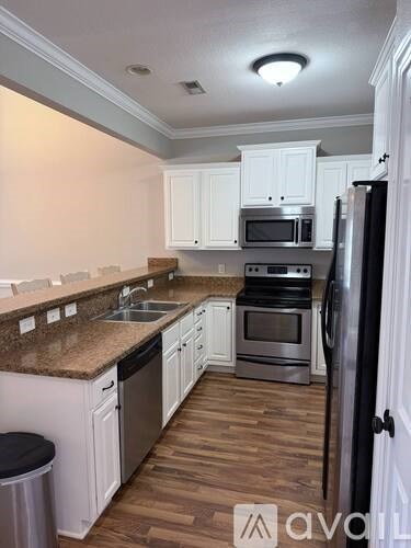 A kitchen with white cabinets and a granite counter top.
