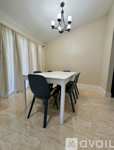 A dining room with a table and chairs.