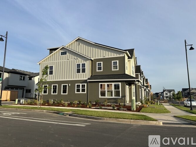 A large two-story house with a grey roof and a metal siding exterior.