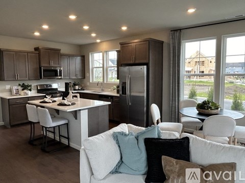 A modern kitchen with a dining area and a living room.