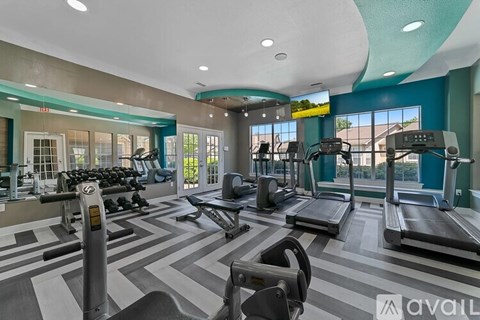 A gym with treadmills, elliptical machines, and dumbbells.