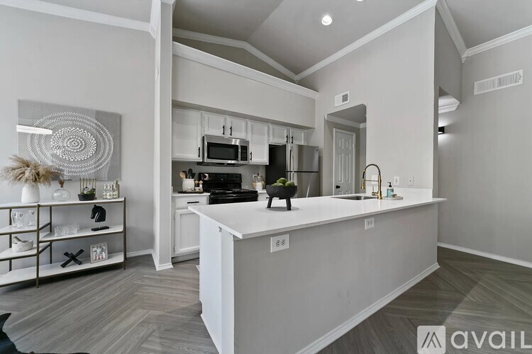 A modern kitchen with a white island and stainless steel appliances.