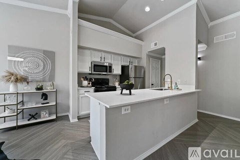 A modern kitchen with a white island and stainless steel appliances.