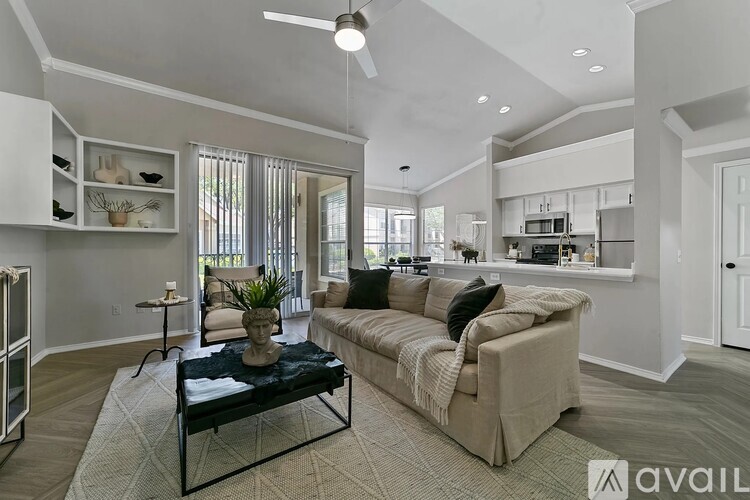 A living room with a couch, a coffee table, and a ceiling fan.