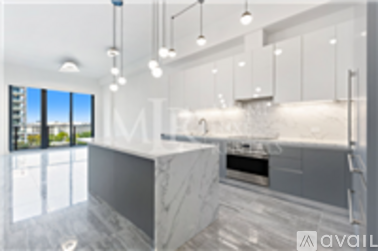 A modern kitchen with a marble countertop and stainless steel appliances.