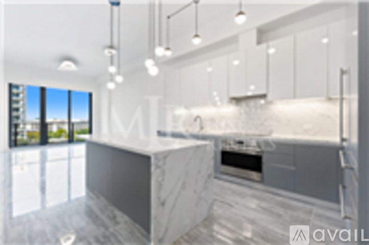 A modern kitchen with a marble countertop and stainless steel appliances.