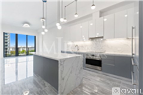 A modern kitchen with a marble countertop and stainless steel appliances.