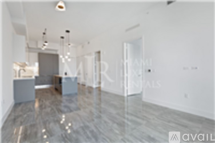 A spacious room with marble flooring and a white ceiling.