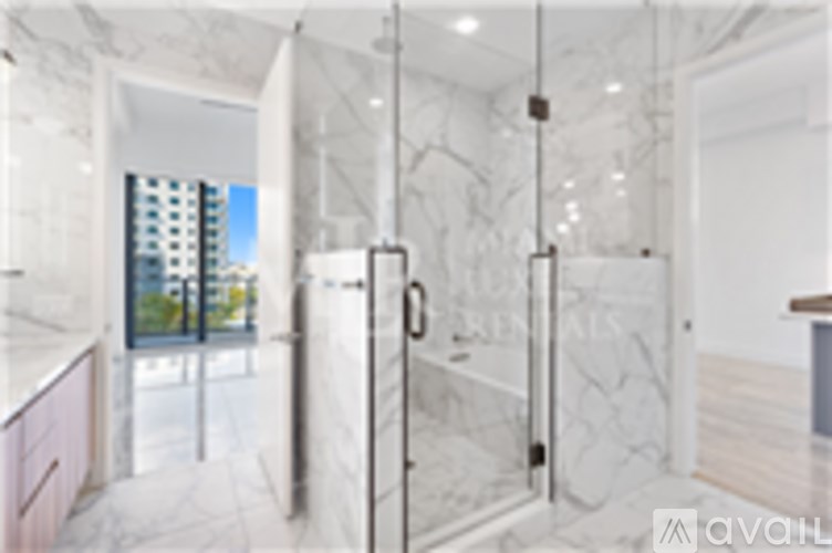 A bathroom with marble walls and a walk-in shower.