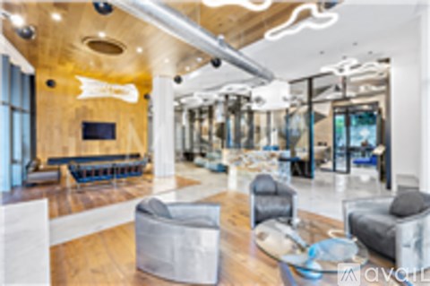 A living room with a grey couch and a wooden floor.