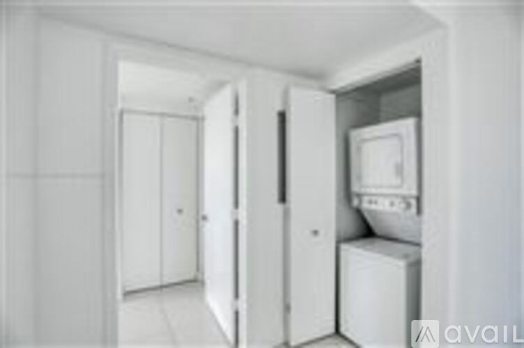 A white kitchen with a fridge and a microwave.